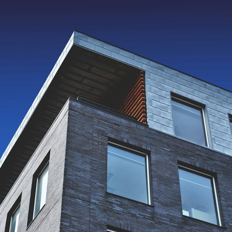 Bâtiment moderne avec un toit en surplomb et des fenêtres carrées.