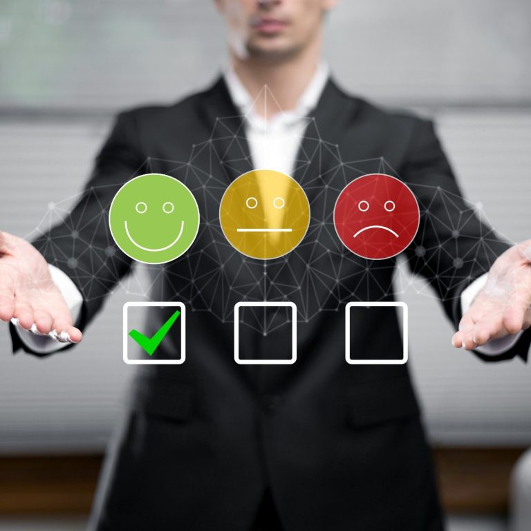 Homme en costume présentant des icônes de feedback : heureux, neutre, triste.